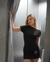 Minivestido negro ajustado al cuerpo, con escote asimétrico y detalle de frunce con aplique brillante en la falda.
