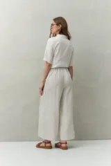 Pantalón palazzo color crema, de tiro medio con cintura elastizada en la parte posterior. Confeccionado en mezcla de lino y viscosa.