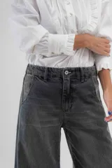 Pantalón de jean azul de pierna ancha y tiro medio, con cinco bolsillos y pespuntes a contratono.