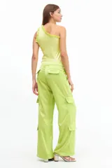 Pantalón cargo verde lima de satén, tiro medio y corte holgado con múltiples bolsillos.