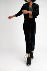 Pantalón jogger negro de terciopelo con cintura media ajustable con cordón, bolsillos laterales tipo cargo y puños elásticos.