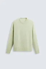Sweater verde claro tejido con lana y alpaca, de corte regular, cuello redondo y manga larga con terminaciones en rib.