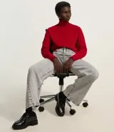 Blusa de punto color blanco, con cuello alto, manga larga y diseño liso.