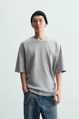 Camiseta azul marino de corte holgado, confeccionada en algodón con cuello redondo y mangas cortas. Presenta un efecto de lavado que le da una apariencia única.