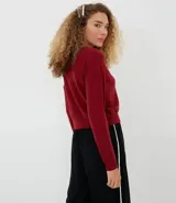 Sweater color marrón de punto con cuello redondo y mangas largas.