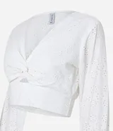 Blusa cropped de laise blanca con escote en pico, detalle torcido en el busto y manga corta abullonada.