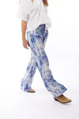 Pantalón fluido con estampado abstracto en tonos azules y blancos, con bolsillos laterales.