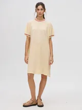 Vestido corto color crema con textura de red y detalles en color borgoña en cuello y mangas.