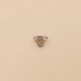 Anillo dorado con base plateada, con diseño de cruz y árbol.