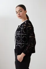 Chaqueta corta color crudo, tejida a crochet con diseño calado.