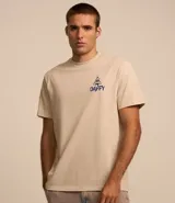 Remera de algodón color beige, de corte recto y manga corta. Estampa en la espalda con el personaje Pato Lucas disfrazado de esqueleto y la frase "Trick or Treat" en letras azules.