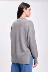 Cárdigan de punto color gris con escote en V, cierre con botones y bolsillos frontales.