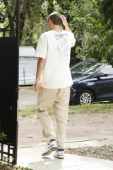 Remera blanca de algodón con estampado en la espalda con la frase "Follow the Waves" y dibujos de conchas marinas en color celeste.