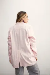 Blazer celeste de lino con solapas de muesca, cierre cruzado con botones, bolsillos delanteros con solapa y corte holgado.