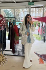 Pantalón de jean acampanado color blanco con costuras verticales en la parte delantera.