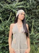 Vestido corto con lentejuelas color verde esmeralda, escote en V profundo y espalda descubierta.