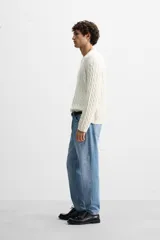 Pantalón de jean celeste de corte slim fit y tapered, con cinco bolsillos, efecto lavado y cierre frontal con cremallera y botón.