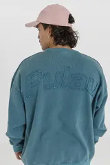 Buzo celeste con cuello redondo y mangas largas. Estampado con el nombre de la marca en la espalda.