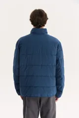 Campera puffer azul marino con cuello alto y cierre frontal con cremallera.