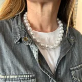 Collar corto de perlones blancos grandes, con cierre de mosquetón de acero y cadena para regular el largo.