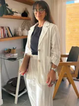 Blazer de lino color crudo con rayas verticales finas en color azul marino, con solapas clásicas, cierre con dos botones de madera y bolsillos delanteros.