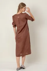 Vestido azul de lino, corte recto, largo midi, escote en V, manga corta, bolsillos laterales y tajos en los laterales.