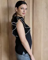 Musculosa blanca de punto con cuello redondo y mangas con volados.