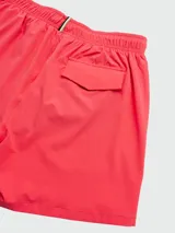 Short de baño color coral con cintura elástica ajustable con cordón rojo y logo estampado en la pierna izquierda.