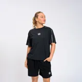 Remera negra de corte holgado con cuello redondo y mangas cortas con doble línea blanca en los hombros. Logo de Umbro estampado en blanco en el pecho.