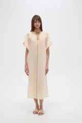 Túnica color crema de algodón con mangas cortas anchas, cuello en V y cordón ajustable.
