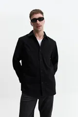 Sobrecamisa color marrón claro de twill de algodón, con cuello clásico, cierre frontal con botones a tono, dos bolsillos de parche con solapa abotonada en el pecho y mangas largas con puños abotonados.