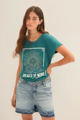 Remera negra de algodón y modal con estampa de un girasol y la frase "Peace of Mind".