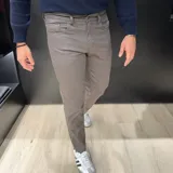 Pantalón de vestir negro, de corte recto, con bolsillos laterales y traseros. Se ajusta a la cintura con cinturón de cuero marrón.