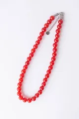 Collar corto de cuentas redondas de vidrio color naranja.