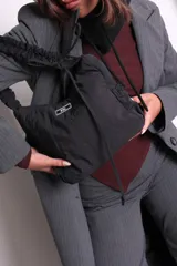 Bolso negro de nylon con textura sutil y manija fruncida.