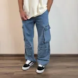 Pantalón jean celeste, corte holgado, con múltiples bolsillos cargo.