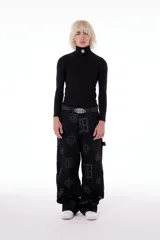 Pantalón negro de gabardina de algodón con estampado de logos. Tiene tiro medio, bolsillos delanteros y traseros.