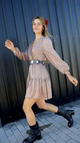 Vestido corto color marrón claro con hilos plateados, escote en V cruzado y mangas largas abullonadas.