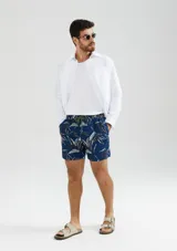 Short de baño azul con estampado de hojas en tonos verde y blanco.