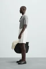 Bermuda de algodón color marrón oscuro, de corte regular fit, con cintura elástica ajustable mediante cordón. Presenta bolsillos laterales y un bolsillo trasero de vivo.