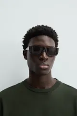 Camiseta verde oscuro de corte holgado, confeccionada en tejido de algodón grueso. Tiene cuello redondo y mangas cortas sin costura en la sisa.