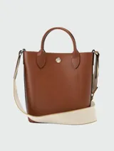 Bolso tote Longchamp modelo Épure XS, color marrón cuero, con correa larga de tela color crudo.