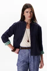Chaqueta azul marino de lino con corte clásico, vivos a contratono en color crema y forro estampado con motivos florales en tonos verdes y azules.