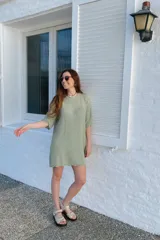 Vestido corto tejido color verde claro, de corte recto y mangas cortas.