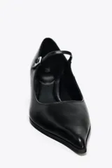 Zapato de cuero negro con tacón kitten, tira con hebilla ajustable y punta fina.