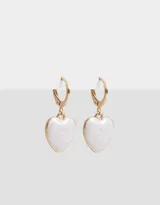 Aros dorados tipo argolla con dije colgante en forma de corazón blanco con diseño marmolado.