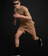 Remera deportiva de hombre, color amarillo mostaza, de manga corta y cuello redondo. Presenta un pequeño logo circular bordado en el pecho.