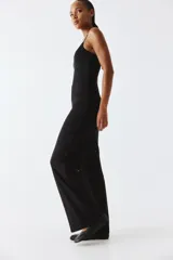Pantalón negro de punto suave, tiro alto, cintura elástica y piernas amplias.