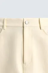 Bermuda color crema de corte recto, con bolsillos laterales y traseros.
