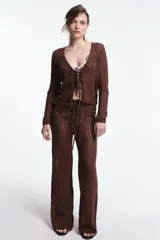 Pantalón de playa marrón de tejido calado, con corte palazzo y cintura con cordón ajustable.